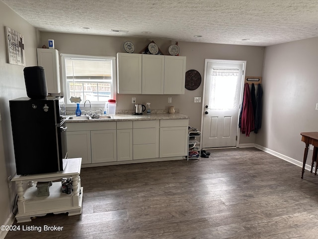 kitchen featuring sink, white cabinets, and a textured ceiling