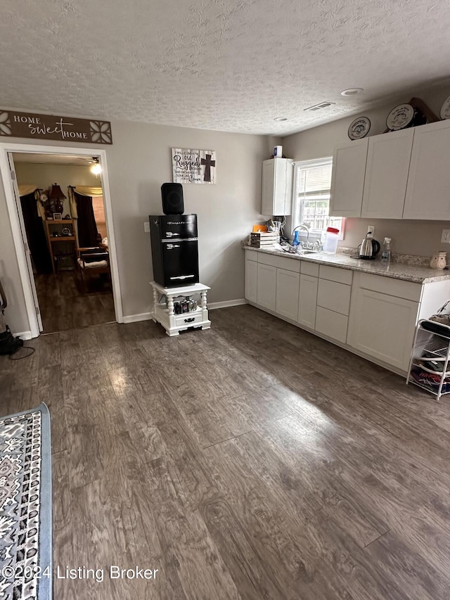 kitchen featuring white cabinets, a textured ceiling, dark wood-type flooring, and sink