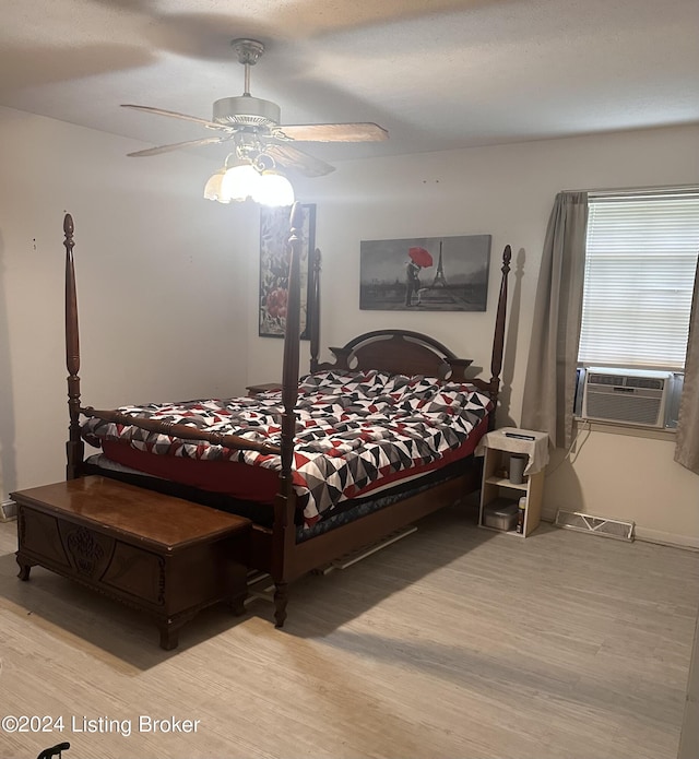 bedroom featuring ceiling fan, cooling unit, and light wood-type flooring