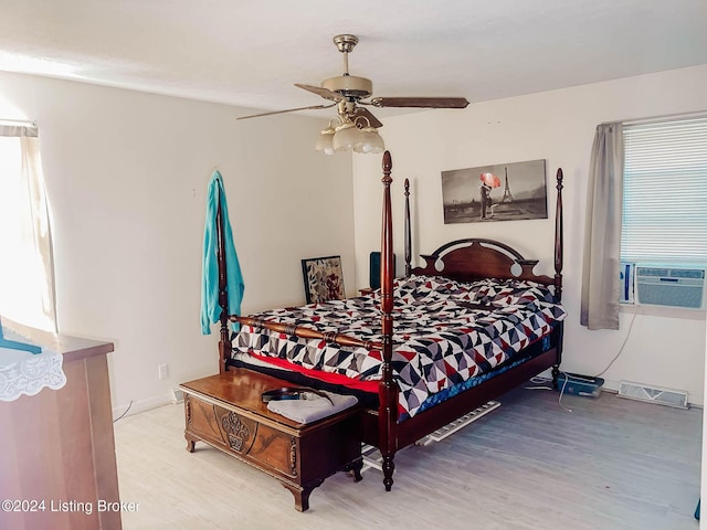 bedroom featuring ceiling fan, cooling unit, and light wood-type flooring