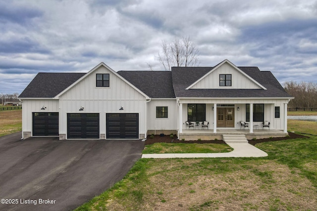 modern farmhouse featuring a front yard, a porch, and a garage