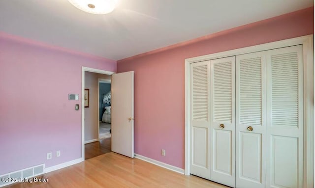 unfurnished bedroom featuring light wood-type flooring and a closet