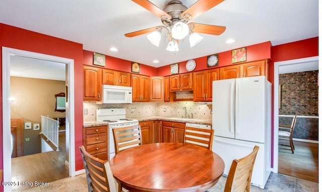 kitchen with white appliances, backsplash, ceiling fan, and sink