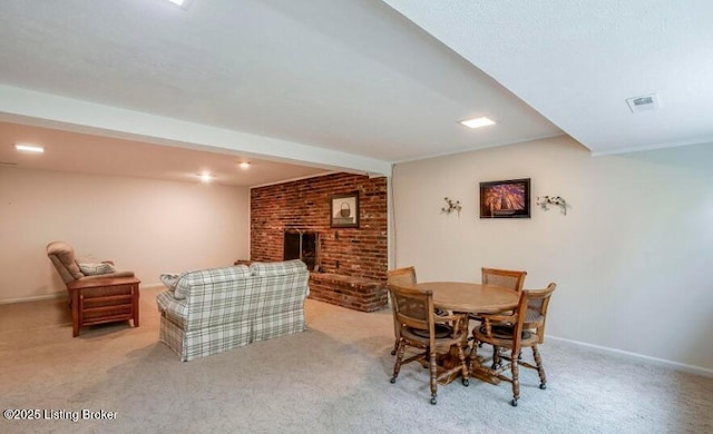 carpeted dining space featuring beam ceiling and a fireplace