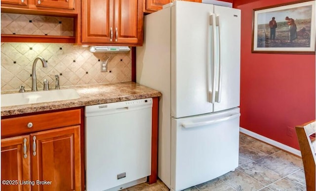 kitchen featuring decorative backsplash, sink, light stone counters, and white appliances