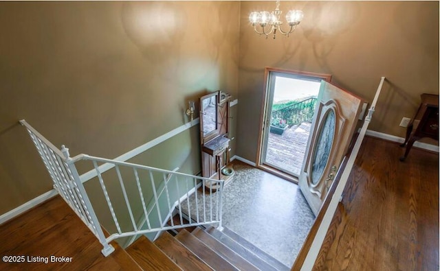 entrance foyer featuring dark wood-type flooring and an inviting chandelier