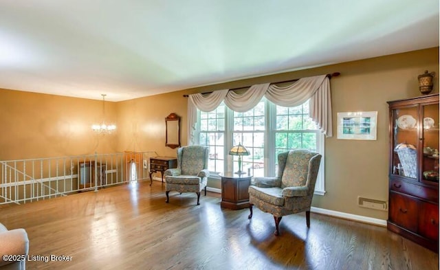 living area with an inviting chandelier and hardwood / wood-style flooring