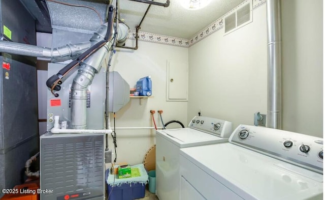 laundry room with washer and dryer and a textured ceiling