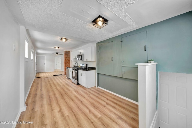 kitchen featuring white cabinetry, a textured ceiling, light hardwood / wood-style flooring, appliances with stainless steel finishes, and ceiling fan