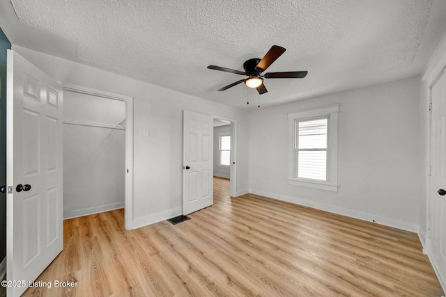 unfurnished bedroom featuring a textured ceiling, light hardwood / wood-style floors, a closet, and ceiling fan