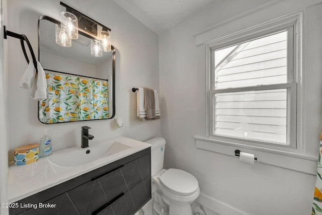 bathroom with vanity, toilet, and a textured ceiling