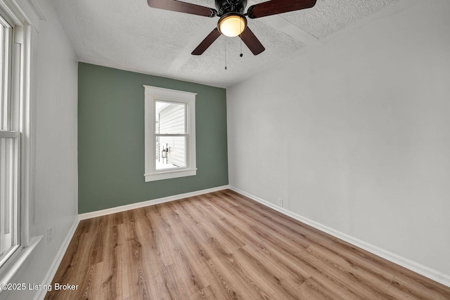 unfurnished room featuring ceiling fan, light hardwood / wood-style flooring, and a textured ceiling