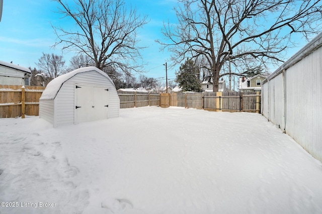 snowy yard with a storage shed