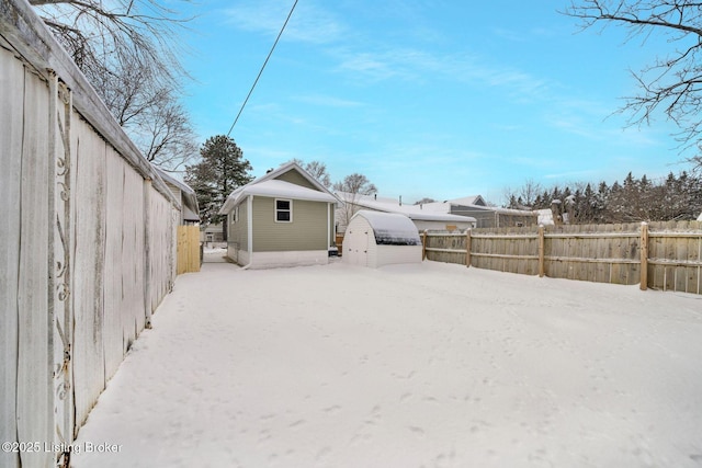 yard covered in snow featuring an outbuilding