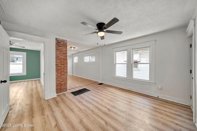 empty room with ceiling fan, light hardwood / wood-style floors, and a textured ceiling