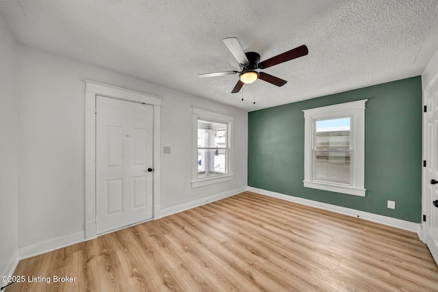 foyer entrance featuring a textured ceiling, light hardwood / wood-style flooring, and ceiling fan