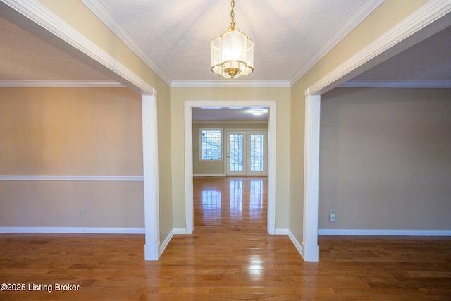 hall featuring hardwood / wood-style floors, crown molding, a chandelier, and a textured ceiling