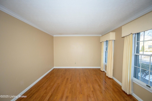 spare room featuring wood-type flooring and ornamental molding