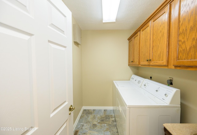 washroom with cabinets, a textured ceiling, and separate washer and dryer