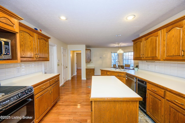 kitchen featuring a kitchen island, stainless steel appliances, tasteful backsplash, sink, and hanging light fixtures