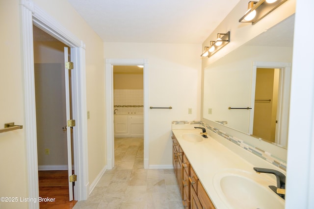 bathroom featuring vanity, decorative backsplash, and a bathing tub