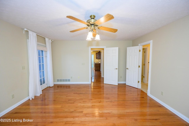 unfurnished bedroom featuring light wood-type flooring, ceiling fan, and a textured ceiling