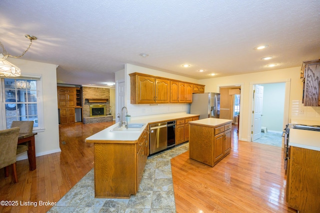 kitchen with kitchen peninsula, appliances with stainless steel finishes, backsplash, a kitchen island, and sink