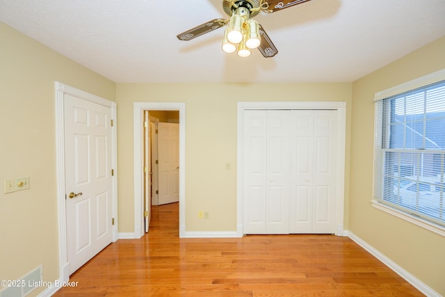 unfurnished bedroom with ceiling fan, a closet, and light hardwood / wood-style flooring