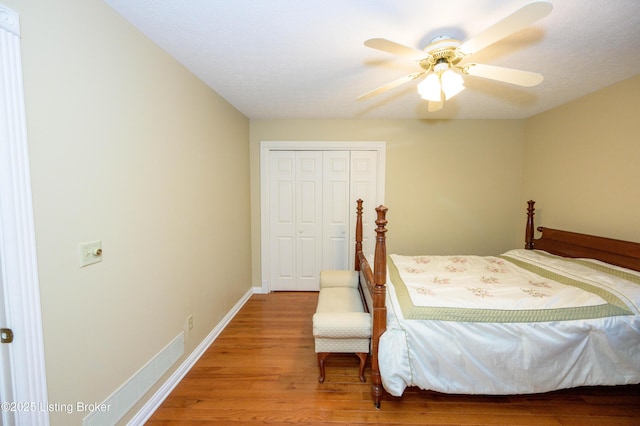 bedroom featuring ceiling fan, a closet, and hardwood / wood-style floors