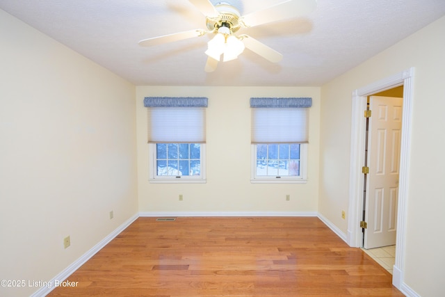 spare room with ceiling fan, light hardwood / wood-style floors, and a textured ceiling