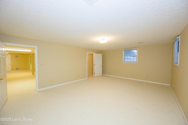 empty room featuring light colored carpet and a textured ceiling