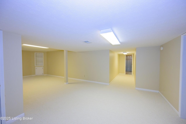 basement with a textured ceiling and light carpet