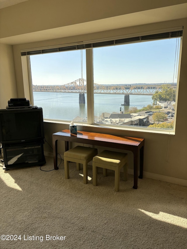 dining room featuring carpet floors and a water view