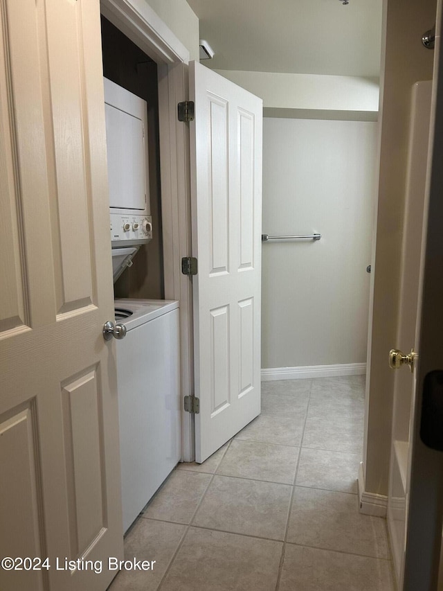 clothes washing area featuring stacked washer / dryer and light tile patterned floors