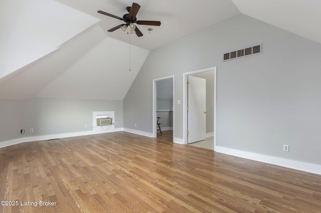 bonus room featuring a wall mounted air conditioner, ceiling fan, light wood-type flooring, and lofted ceiling