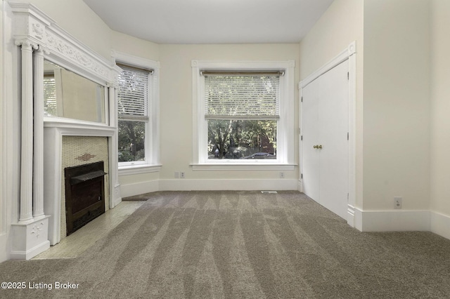 unfurnished living room with a fireplace and carpet floors