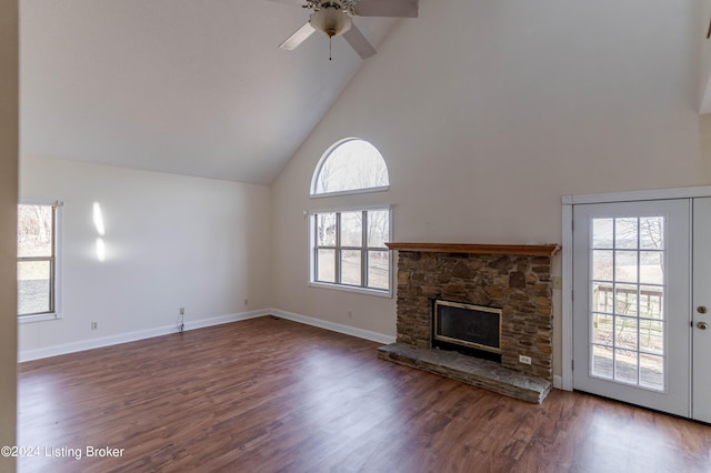 unfurnished living room featuring french doors, dark hardwood / wood-style flooring, ceiling fan, high vaulted ceiling, and a fireplace