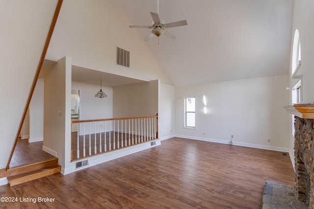 unfurnished living room with a fireplace, ceiling fan, hardwood / wood-style floors, and high vaulted ceiling