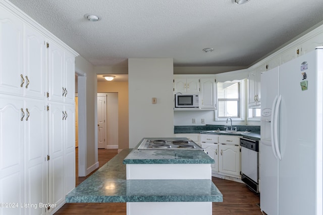 kitchen featuring white appliances, a kitchen island, sink, dark hardwood / wood-style floors, and white cabinetry