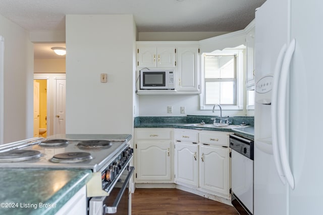 kitchen featuring white appliances, white cabinets, sink, a textured ceiling, and dark hardwood / wood-style flooring