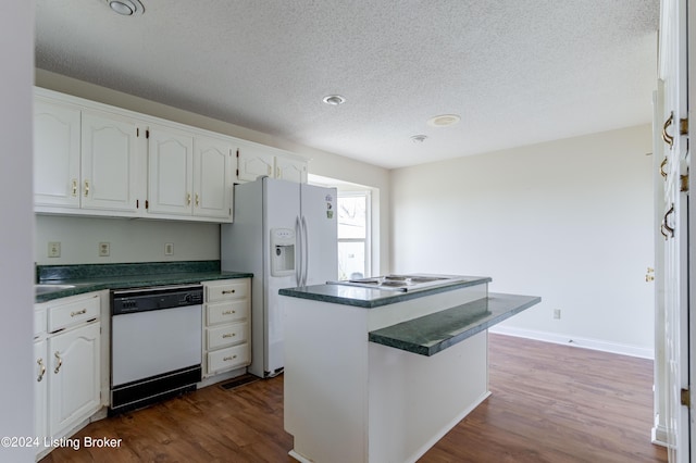 kitchen featuring a textured ceiling, white appliances, white cabinets, dark hardwood / wood-style floors, and a kitchen island