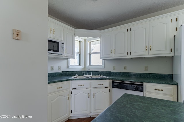 kitchen with white cabinets, white appliances, sink, and a textured ceiling