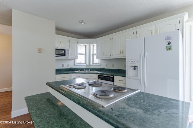 kitchen with a textured ceiling, white appliances, sink, dark hardwood / wood-style floors, and white cabinetry