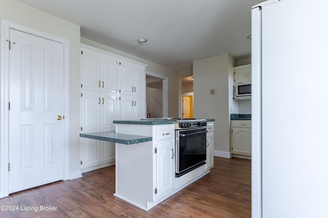 kitchen with range with electric cooktop, a textured ceiling, hardwood / wood-style flooring, white cabinets, and a center island