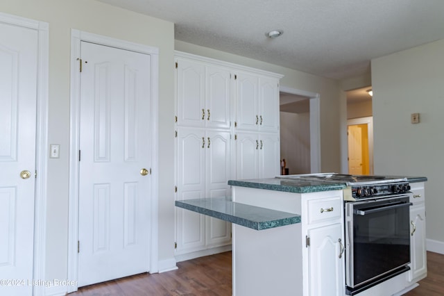 kitchen featuring white cabinets, hardwood / wood-style floors, a center island, and range with gas cooktop