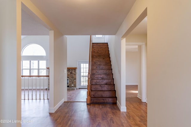 staircase featuring wood-type flooring and a fireplace