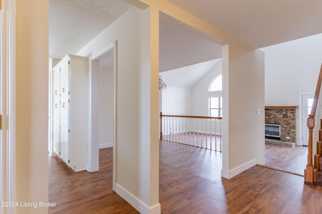 hall featuring dark wood-type flooring and vaulted ceiling