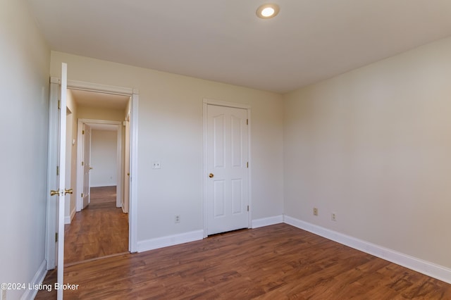 unfurnished bedroom with dark wood-type flooring