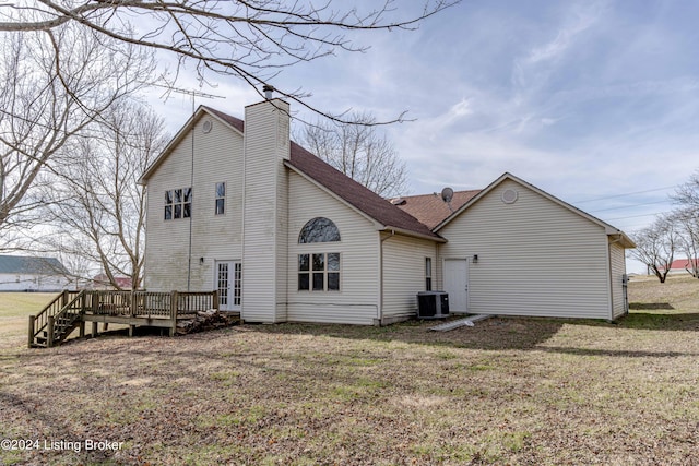 rear view of house featuring central AC unit, a deck, a lawn, and french doors