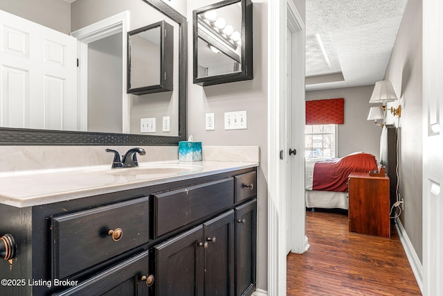 bathroom with a textured ceiling, hardwood / wood-style flooring, and vanity